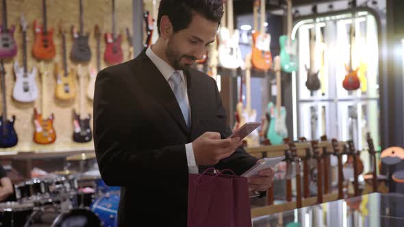 A Middle Eastern Man Using Mobile Phone To Purchase Product 