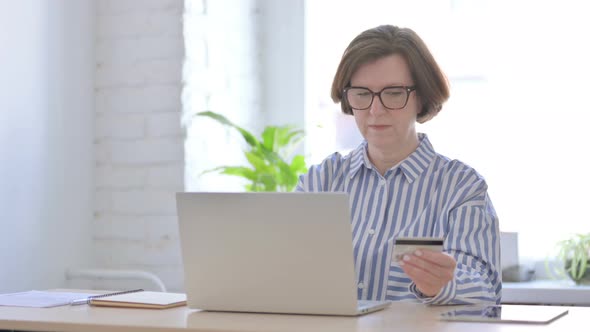 Happy Senior Woman Shopping Online on Laptop