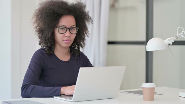 Thumbs Down By African Woman with Laptop