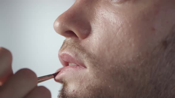 Extreme Close Up of Applying Lip Gloss on Man