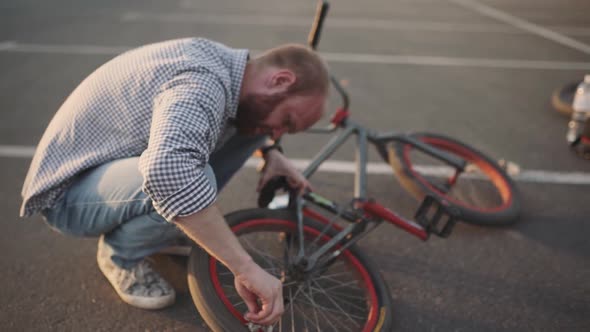 a Young Man Cleans His Bmx Bicycle From Dirt