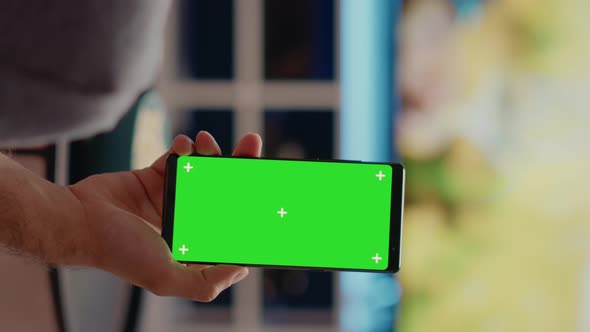 Vertical Video Person Holding Mobile Phone with Green Screen Vertically