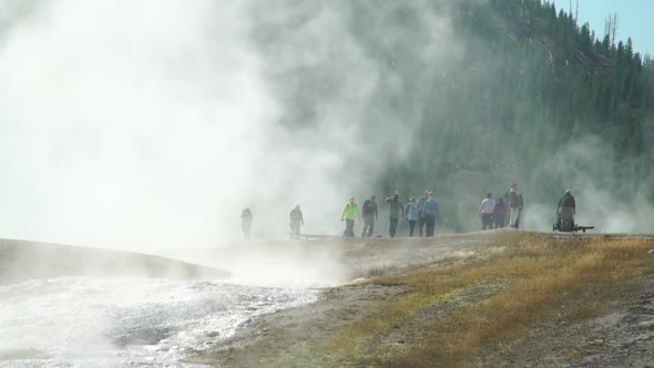 Visitors to the magnificent Prismatic Hot Springs in Yellowstone National Park are obscured by steam