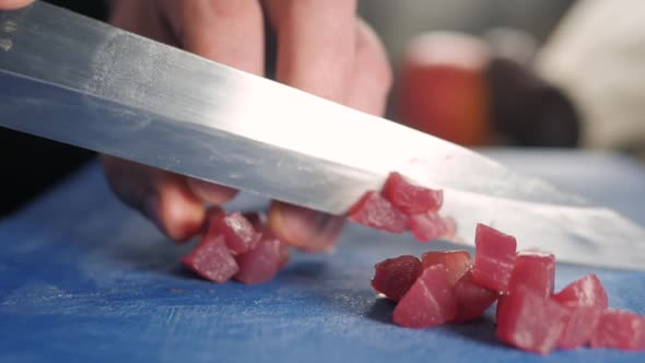 Close Up Macro on the Hands of the Japanese Sushi Sashimi Chef 's Knife Slice the Raw Tuna Salmon