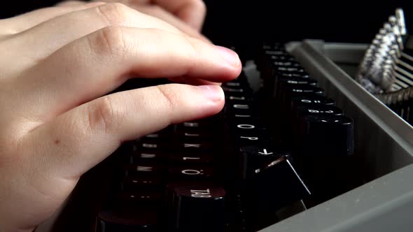 The girl is typing on a retro typewriter.