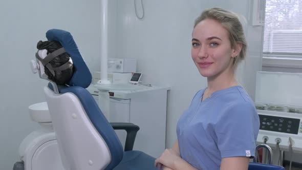 Dentist Assistant Nurse on Background of Dentists Chair in Dental Office