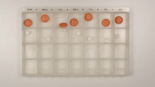 Male nurse hand puts down a pills into a pill organizer