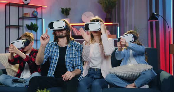 Family Sitting on the Couch at Home in the Evening and Using Virtual Reality Headset