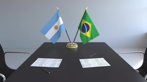 Flags of Argentina and Brazil and Papers on the Table