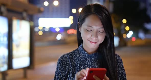 Woman read on smart phone in city at night