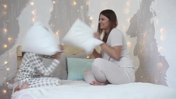Mom and Son Beat Each Other with Pillows Having a Good Mood