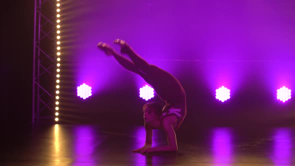 A Flexible Professional Female Athlete Performs Complex Acrobatic Elements of Rhythmic Gymnastics