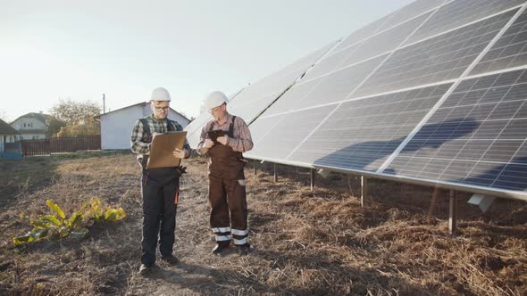 Two Engineers Analyzing Work of Alternative Solar Batteries on a Factory