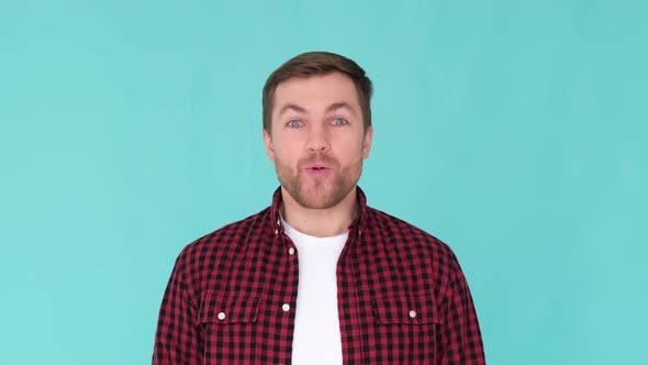 Young Cheerful Guy of European Appearance Isolated on Blue Studio Background Say Wow Surprised Man