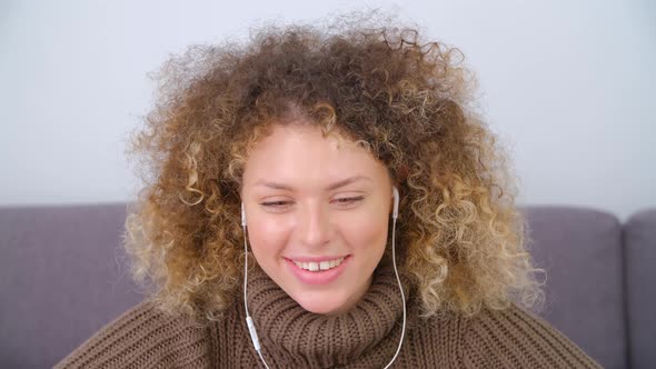 Curly freelancer female talking on laptop web camera wearing head set in 4k stock video