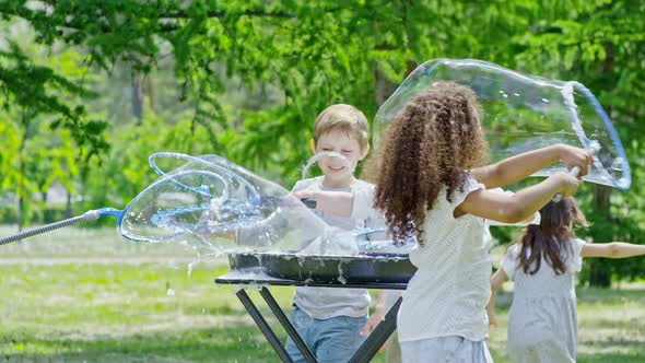 Excited Kids Playing with Soap Bubbles in Park