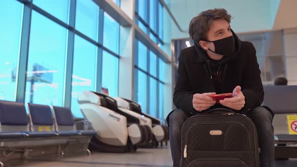 Young Businessman Waiting for Delayed Flight Airplane in Airport Modern Waiting Room Crowded with