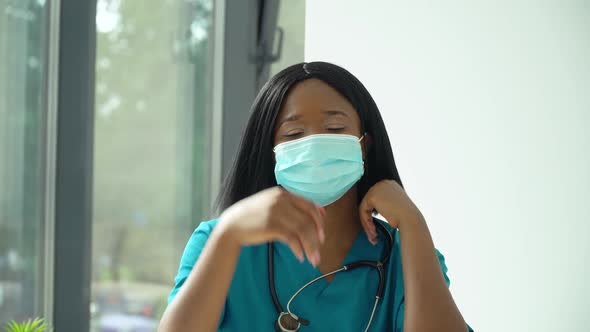 Young African Woman Doctor in Blue Protective Mask Looking at the Camera