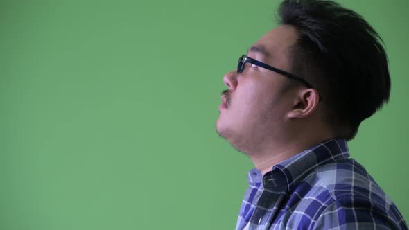 Closeup Profile View of Happy Young Overweight Asian Hipster Man Smiling