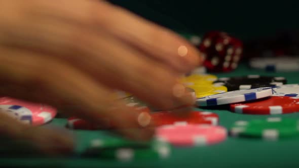 Female hands collecting huge pile of chips off poker table. Leader winning prize