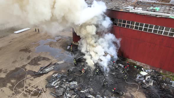 Aerial View of Firefighters Extinguishing Fire in Industrial Area