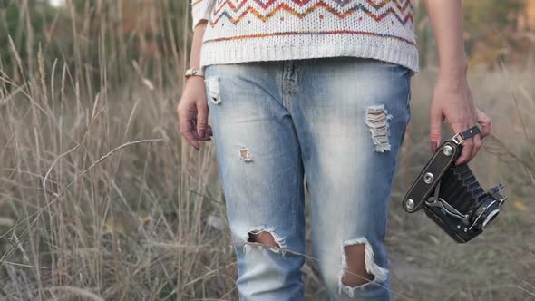 Girl Walks in the Park with a Retro Camera