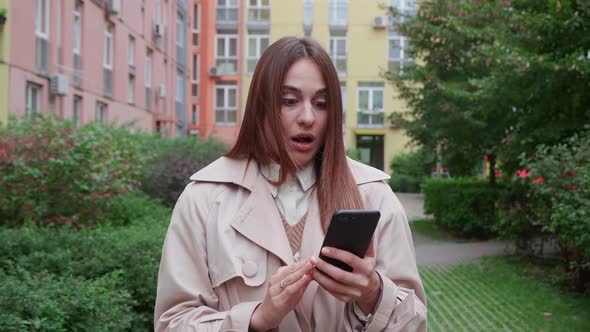 Happy Fun Charismatic Young Brunette Woman Holding Smartphone Near Building Background