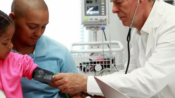 Male doctor checking patient blood pressure