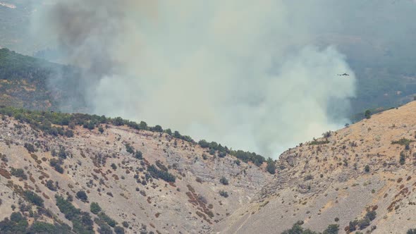 Helicopter flying over wildfire burning in Utah