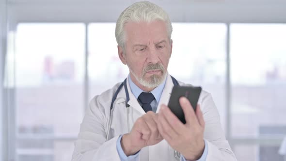 Old Senior Doctor Using Smartphone in Clinic