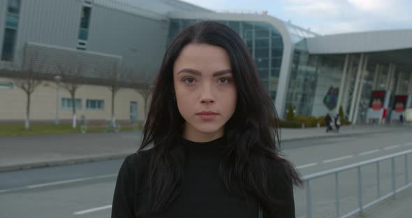 A Beautiful Girl Is Smiling and Looking Into the Camera When She Standing Near the Airport