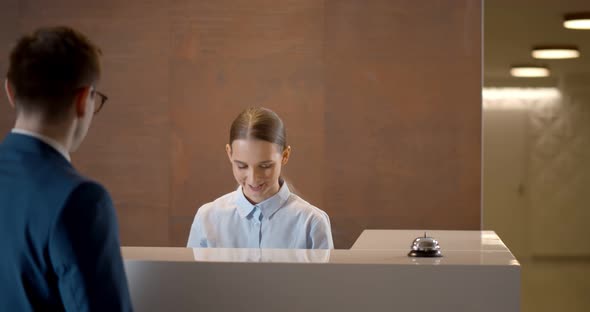 Young Male Guest Taking Room Key at Hotel Checkin Desk