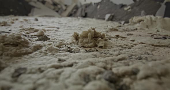 Close up shot of old mineral wool under floor screed in an old building. Camera moves slowly forward