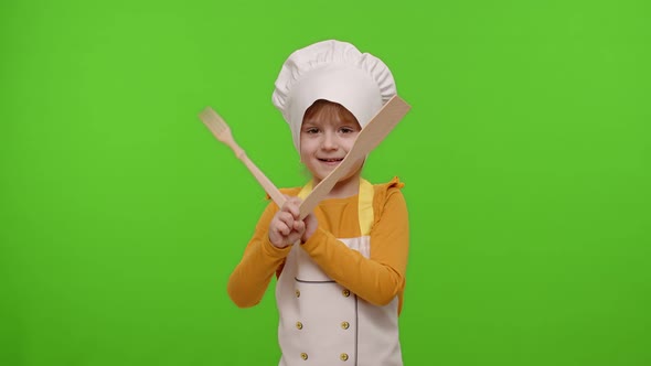 Funny Child Girl Kid Dressed Cook Chef Baker in Apron and Hat Dancing Fooling Around Making Faces