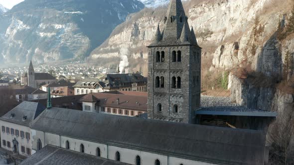 Low angle aerial om imposing old church tower of the Saint Maurice Abbey in an idyllic town