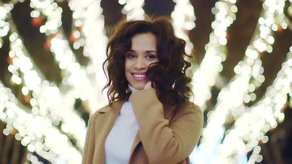 Closeup Portrait of a Young Woman on the Background of Festive Lights and Bokeh