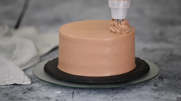 Chef Decorating Chocolate Cake with Cream