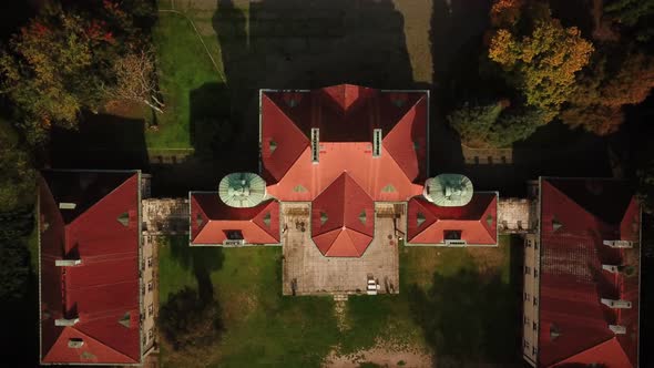 AERIAL zoom out of Castle. Flight over beautiful castle; located in landscape park with green trees