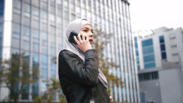 Portrait of Young Stylish Muslim Business Woman in Hijab Talking on the Phone in Business Area