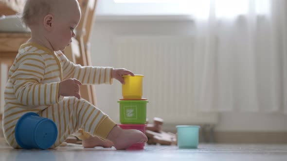 Little Baby Playing with Educational Colorful Toys at Home Sitting on Floor