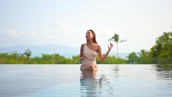 Young asian woman enjoy around outdoor swimming pool for leisure