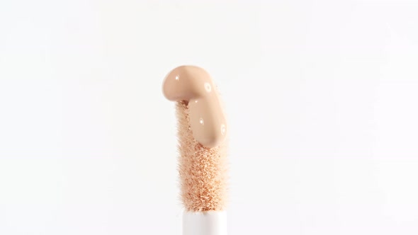 Makeup Liquid Beige Foundation Pouring on Makeup Brush Closeup