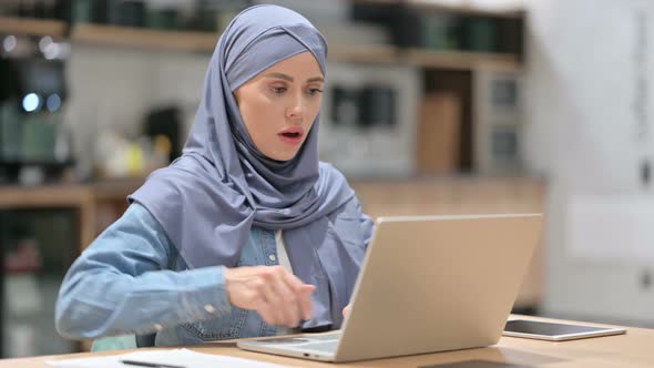 Young Arab Woman with Back Pain Using Laptop at Work
