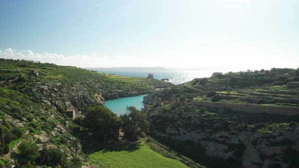 AERIAL: Magrr Ix-Xini Bay with Beautiful Clear Colourful Water Reflecting Sun