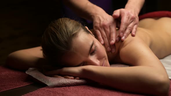 A male master makes a massage to a young woman. Slow motion
