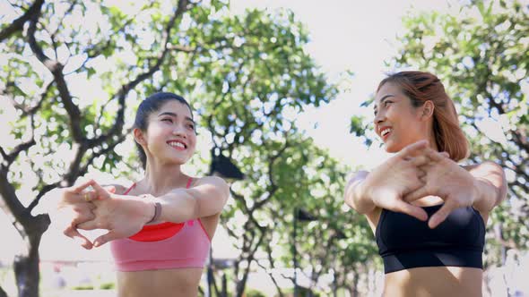 Female Friends Doing Stretching Exercise in Park