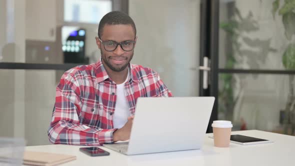 African Man with Laptop Shaking Head As Yes Sign