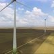 Aerial shot of power generating windmills over agricultural fields - VideoHive Item for Sale