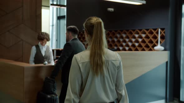 Slow Motion of Group of Guests Checking in Hotel Talking To Friendly Reception Manager