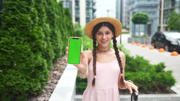 Woman Showing Modern Smartphone with Green Screen for Replacement